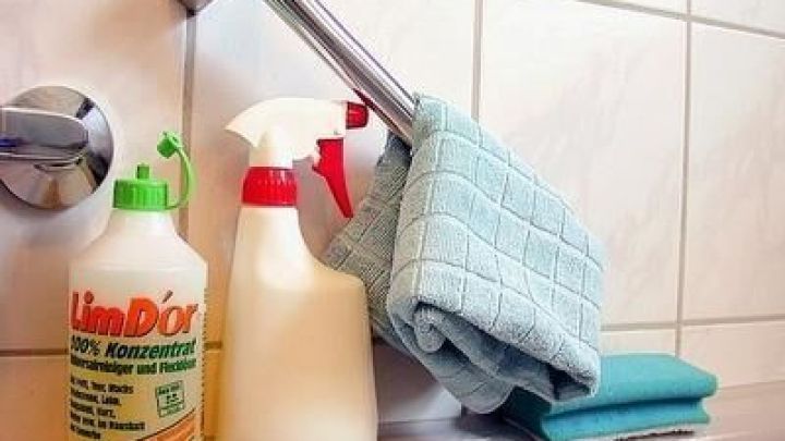 Flasche mit LimDor Orangenreiniger steht neben Spr&uuml;hflasche auf Wanne; Tuch h&auml;ngt an Duschkopf; Schwamm daneben.