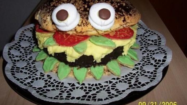 Eine Big Mac Torte mit dekorativen Augen liegt auf Spitzendeckchen, wirkt wie ein Burger mit Schichten von Creme und Deko. Datum: 21.09.2006.