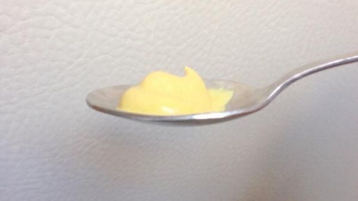 Ein L&ouml;ffel mit gelbem Senf steht schr&auml;g in der Luft, um zu verdeutlichen, wie man Sodbrennen schnell behandeln kann.