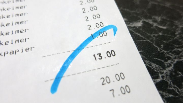 Ein Blatt Papier mit einem blauen Filzstift ist markiert, w&auml;hrend es auf einem dunklen, glatten Untergrund liegt.