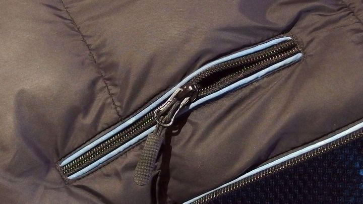 Ein Rei&szlig;verschluss auf einer Jacke klemmt und l&auml;sst sich nicht mehr schlie&szlig;en. Der Stoff ist braun und umschlie&szlig;t den Rei&szlig;verschluss.