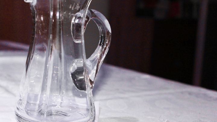 Eine gl&auml;serne Karaffe steht auf einem Tisch und wartet darauf, mit Backpulver und Oxi zur Reinigung von Weinrand genutzt zu werden.