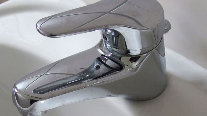 Ein gl&auml;nzender Wasserhahn steht bereit, um Wasser zu liefern, w&auml;hrend sich Kalkablagerungen auf der Oberfl&auml;che zeigen.