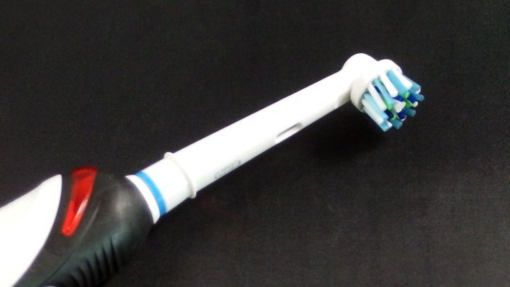 Eine elektrische Zahnb&uuml;rste wird auf einem schwarzen Hintergrund gezeigt, bereit zur Reinigung f&uuml;r eine bessere Mundpflege.