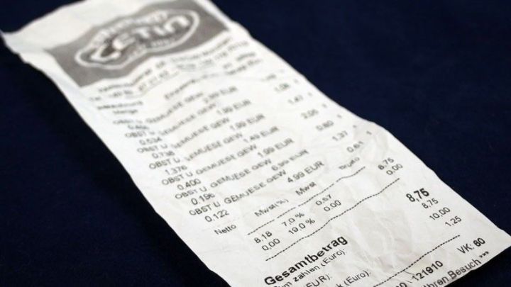 Ein Kassenbon liegt auf einem dunklen Untergrund und zeigt detaillierte Einkaufsinformationen sowie Betr&auml;ge.