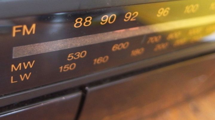 Ein Radio spielt auf der FM-Frequenz, w&auml;hrend die Anzeige zwischen den Sendern wechselt. Die Umgebung ist hell und warm.