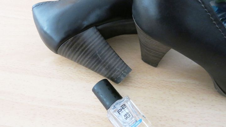 Schwarze Schuhabs&auml;tze stehen neben einer Flasche Klarlack auf einem hellen Tisch, bereit f&uuml;r die Pflege und den Schutz.