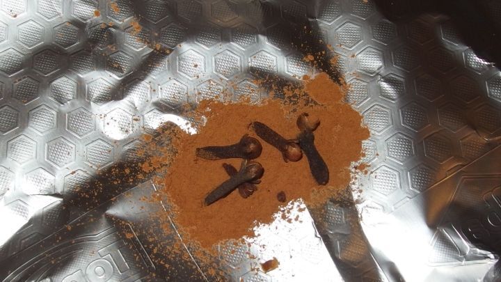 Nelken und Zimt liegen auf Aluminiumfolie, w&auml;hrend sie darauf warten, in einem Rezept verwendet zu werden.