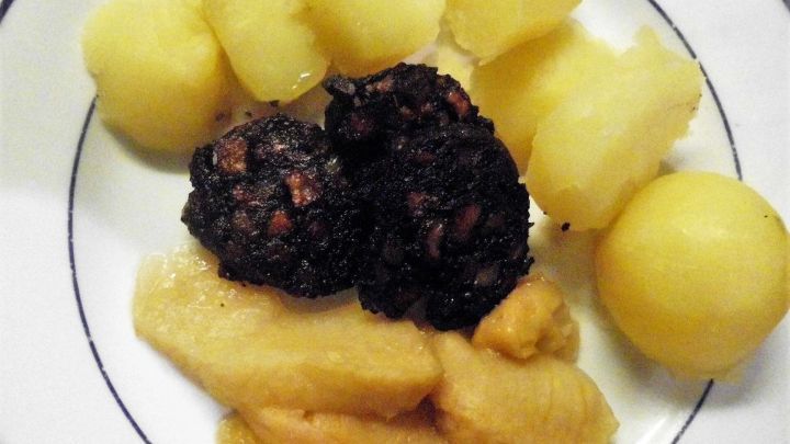 Kartoffeln und Blutwurst auf Teller, kombiniert mit Apfelmus. Traditionelles deutsches Gericht, serviert als &bdquo;Himmel und Erde&ldquo;.