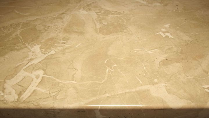 Marmorfensterbank glänzt glatt, zeigt eine beige, strukturierte Oberfläche, perfekt für elegantes Wohndesign.