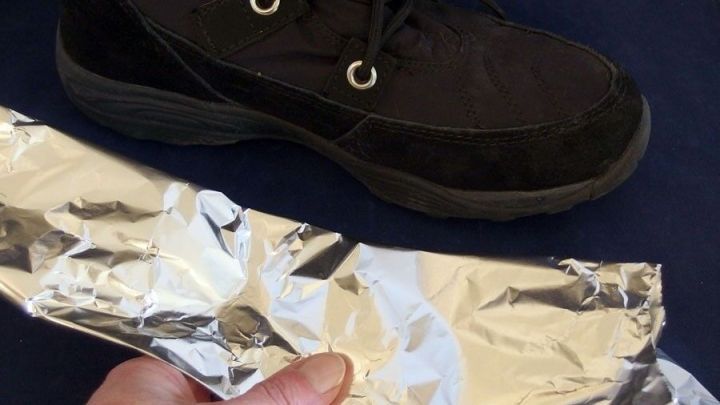 Ein Hand h&auml;lt einen Streifen Aluminiumfolie, w&auml;hrend ein schwarzer Schuh daneben liegt, um damit f&uuml;r W&auml;rme zu sorgen.