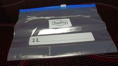 Ein Ziploc-Beutel liegt auf einem Tisch, bereit, um Soßen zu entfetten, während er die Umgebung strukturiert.
