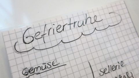 Eine handgeschriebene Liste zu "Gefriertruhe" zeigt auf, was dort aufbewahrt werden kann, wie Gemüse und andere Nahrungsmittel.