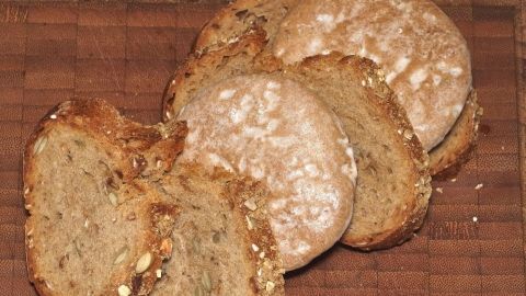 Harte Lebkuchen kann man mithilfe von frischem Brot und einem Frischhalte-Beutel wieder schön weich bekommen. Lebkuchen liegen auf einem Holzbrett und zeigen eine trockene Textur, die darauf hinweist, dass sie weich werden sollen.