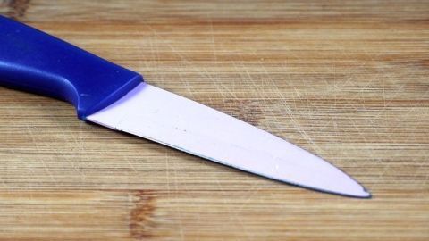 Ein scharfes Messer liegt auf einem Holzbrett, bereit für den Einsatz in der Küche.