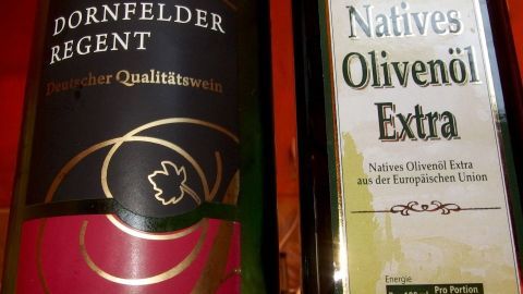 Eine Flasche Rotwein steht neben einer Flasche Olivenöl, beide bereit für die Selbstgemachte Möbelpolitur.