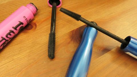 Eingetrockneter wasserfester Mascara wird wieder so wieder geschmeidig und lässt sich weiterhin verwenden. Zwei Mascara mit abgedichteten Bürsten liegen auf einem Tisch, während ihre Verpackungen offen sind, um den Inhalt zu zeigen.
