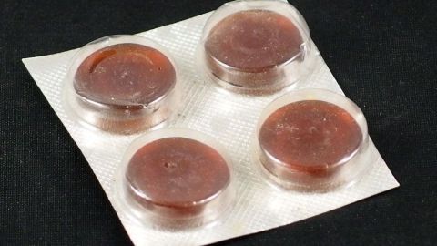 Eine Halschmerztablette mit betäubender Wirkung lutschen, oder Oberflächenanesthätikum-Spray vom Zahnarzt in den Rachenraum sprühen. Das verringert den Würgereiz. Runde Lutschpastillen liegen auf einer Blisterverpackung und könnten helfen, Würgereiz beim Zahnarzt zu verringern.
