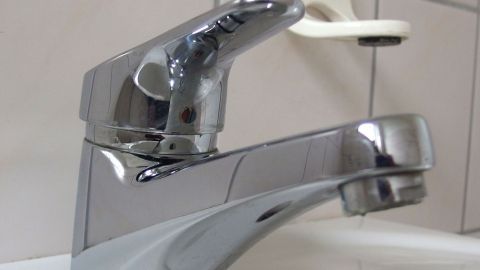 Ein glänzender Chromarmatur im Bad gibt Wasser ab, um die Hygiene und Pflege der Sanitäranlagen zu unterstützen.
