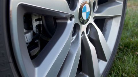 Eine Felge eines Autos, die sauber und glänzend aussieht, steht auf grünem Gras und könnte mit Backofenreiniger gereinigt werden.