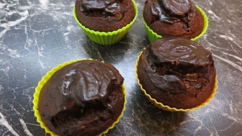 Gibt ein tolles Aroma und Schokostückchen sind auch schon drin.. Schokoladenmuffins mit glanzreicher Marzipandecke liegen auf einer dunklen Marmoroberfläche in bunten Förmchen.