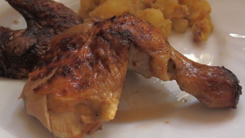 Genieße knuspriges Hähnchen, das in einem köstlichen Milchbad zubereitet wird. Das Bild zeigt eine perfekt goldbraun gebratene Hähnchenstelze, die jedem Essen das gewisse Etwas verleiht. Probiere das Rezept aus! Knuspriges Hähnchen mit goldbrauner Haut liegt auf einem weißen Teller neben einer Portion weicher Kartoffeln.