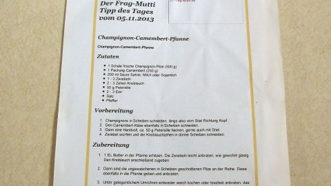 Rezepte sind auf ein Blatt Papier gedruckt, das an einen Schrank geklebt ist, um Kochanleitungen einfach erreichbar zu machen.