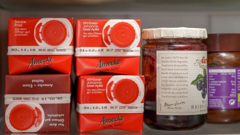 Im Kühlschrank stehen verschiedene rote Verpackungen und Gläser, die zur effizienten Nutzung und zum Stromsparen beitragen.