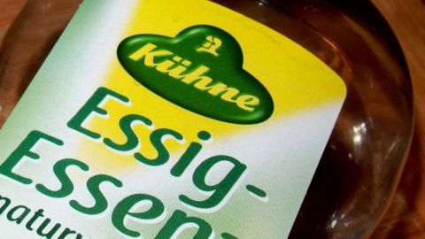 Essigessenz riecht zwar ziemlich streng, ist aber ein super Mittel bei allen hartnäckigen Verschmutzungen im Bad. Eine Flasche Essig-Essenz steht auf einem Tisch, bereit zur WC-Reinigung unter dem Rand.