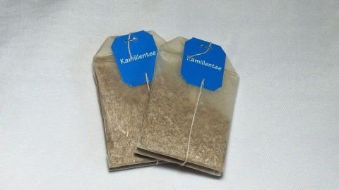 Bei etwas stärkeren Sonnenbrand helfen Kamillenteebeutel. Kamillenteebeutel liegen auf einem weißen Untergrund, bereit zur Anwendung gegen Sonnenbrand.
