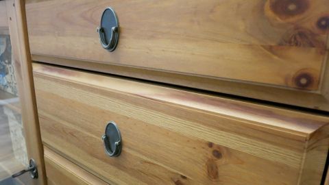 Ein Holzschrank mit zwei Schubladen, die durch einen glänzenden Möbelpflegepolitur geschützt aussehen.