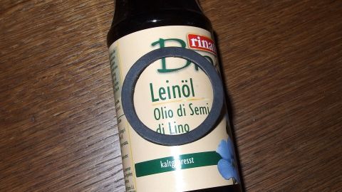 Eine Flasche Leinöl steht auf einem Holztisch, bereit, um Gummidichtungen zu präparieren.