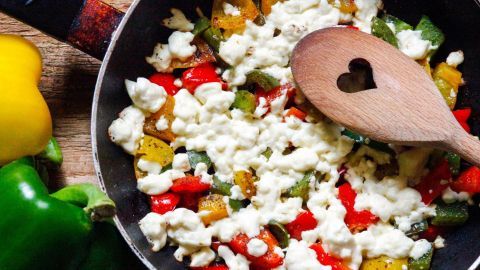 In einer Pfanne wird eine bunte Mischung aus Paprika und Käse erhitzt, um ein gesundes Diabetiker-Rezept zu kreieren.