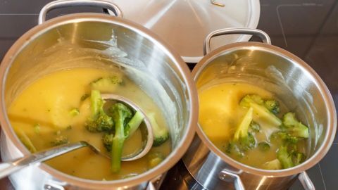 In zwei Töpfen auf dem Herd wird eine Mischung aus Brühe und Brokkoli gekocht, um die Sauce anzudicken.