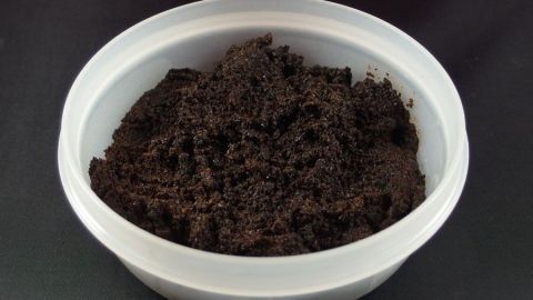 Tupperdose mit kaltem Kaffeesatz füllen, ein paar Tage einwirken lassen, auskippen, und übler Geruch verschwindet. Kaffeesatz liegt in einer weißen Tupperdose und absorbiert Geruch, ideal für frische Aufbewahrung in der Küche.