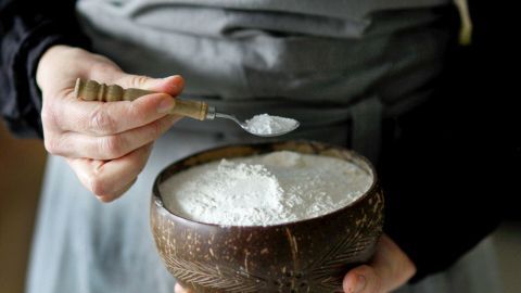 Ich vermische das Backpulver immer mit dem Mehl und gebe es nicht in die Flüssigkeit (z.B. Milch). Eine Person hält eine Schüssel mit Backpulver und einem Löffel, bereit zur Zubereitung von Zutaten.