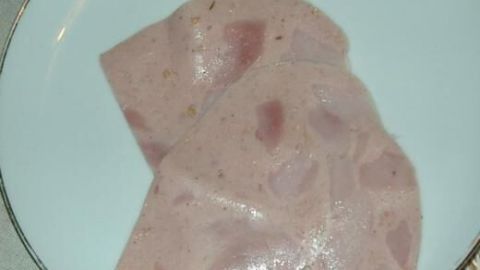 Zwei Scheiben Fleisch liegen ruhig auf einem weißen Teller, vermutlich in einem Restaurant mit Dortmunder Spezialität.