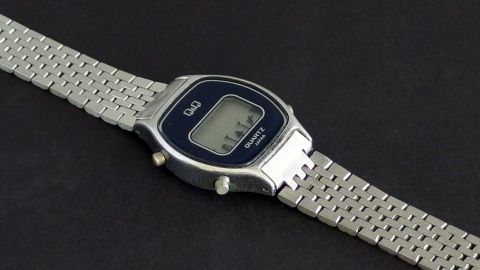 Mit Gebissreiniger das Gliederarmband einer Uhr reinigen. Ein Gliederarmband einer Uhr liegt auf einem schwarzen Untergrund, während es mit Gebissreiniger gereinigt wird.