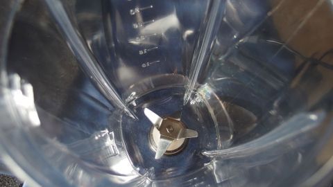 Einen Mixbecher mit Spülmittel und etwas Wasser ganz einfach und schnell reinigen --> So funktionier es! Ein Mixbecher wird von innen gezeigt, wobei die Klingen in der Mitte sichtbar sind; es handelt sich um eine saubere, klare Sicht.