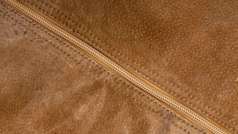 Eine Wildlederjacke in einem nahen Blickwinkel zeigt den Reißverschluss und die strukturierte Oberfläche des Materials.