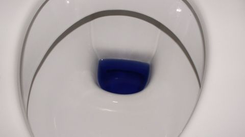 Toilettenbürste in verdünntem Chlorreiniger (z.B. Clorix) in kleinem Gefäß über Nacht stehen lassen. Morgens ist alles sauber. Es ist auch möglich, den Chlorreiniger direkt in den Behälter zu geben, in dem die Klobürste steht. Eine Toilettenschüssel mit blauer Reinigungslösung im Inneren, bereit zur automatischen Reinigung.