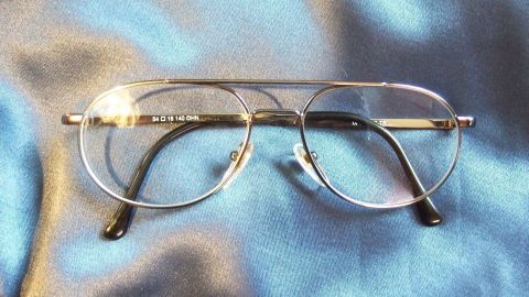 Brille putzen mit Korn und Küchentuch - funktioniert wirklich gut. Eine Brille liegt auf einem blauen Stoff. Sie wird gereinigt, um klare Sicht zu gewährleisten.