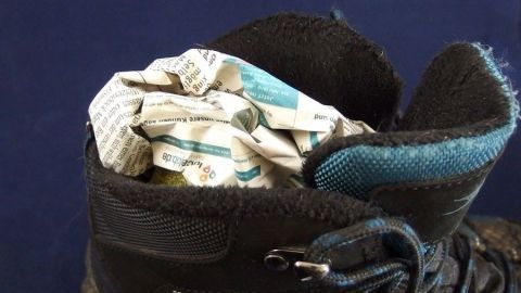 Nasse Schuhe kannst du schnell wieder trocknen, indem du Zeitungspapier hineinlegst. So wird die Feuchtigkeit effektiv aufgenommen. Ein einfacher Trick, der dir hilft, deine Schuhe schnell wieder einsatzbereit zu haben. Wasserdichte Schuhe stehen im Fokus, während zerknülltes Papier zum Trocknen in den Schuhen platziert ist.