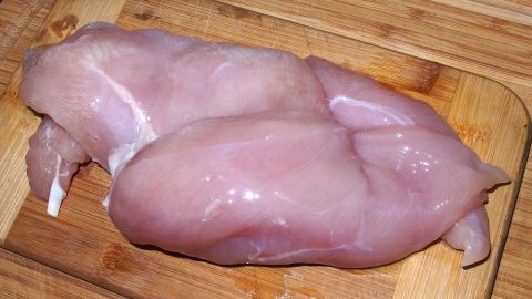 Ein rohes Stück Fleisch liegt auf einem Holzbrett, ideal zum Erkennen von gutem Fleisch.