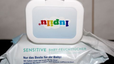 Ein Behälter für Babyfeuchttücher steht auf einer Packung, bereit zur Reinigung der Dunstabzugshaube in der Küche.
