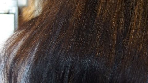 Long, dark hair with a smooth texture showcases the results of a recent Henna färben procedure, enhancing its natural shine.