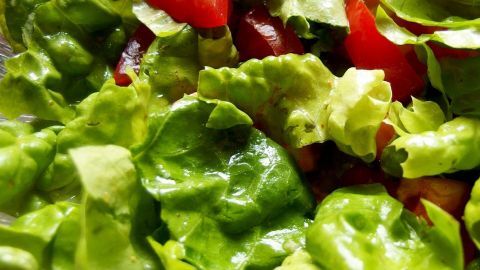 Frischer Salat mit leuchtend roten Tomatenstücken liegt in einer Schüssel, saftig und bereit zum Verzehr in einer Küche.