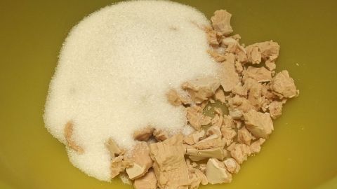 In einer Schüssel liegen Zucker und Hefe, bereit zur schnellen Verarbeitung für Hefeteig.