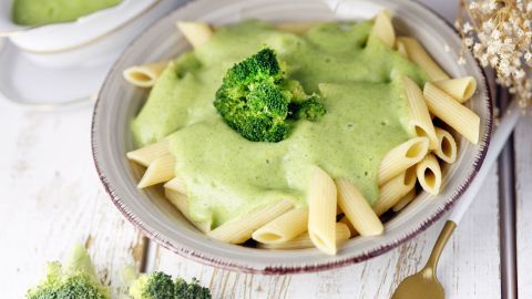 Penne Nudeln sind mit einer cremigen Brokkoli-Sauce überzogen, garniert mit frischem Brokkoli in einem dekorativen Teller.