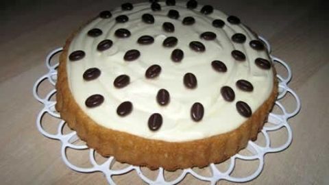 Vanille-Quark-Torte ohne Backen: Schneller Genuss mit lockerem Boden und cremigem Belag, verziert mit Schokobohnen.
